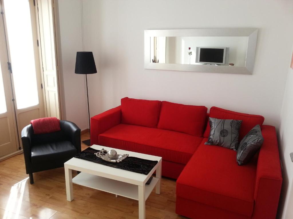 sala de estar con sofá rojo y mesa en Apartamento Montaño 4 Wifi gratis y 2 Baños, en Málaga