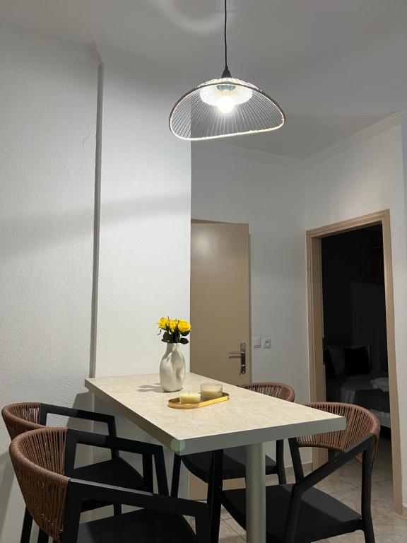 a dining room table with chairs and a vase of flowers at Diktamo Coast Living in Ofrínion