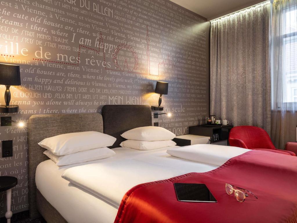 a bedroom with a bed and a wall with writing on it at Mercure Vienna First in Vienna
