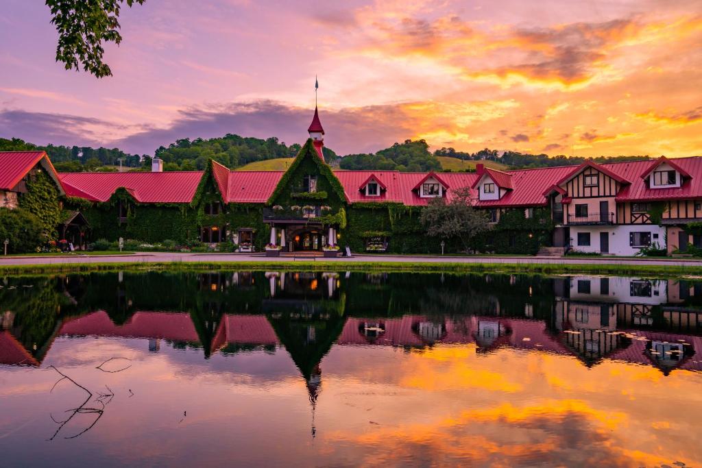 a building with a reflection in the water at sunset at The Highlands at Harbor Springs in Harbor Springs