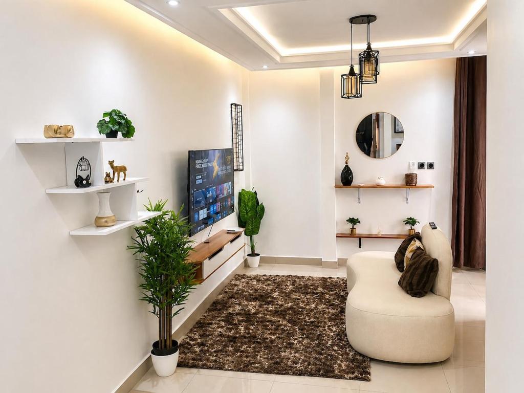 a living room with a couch and a tv at Skyline Residence Apartment in Douala in Douala