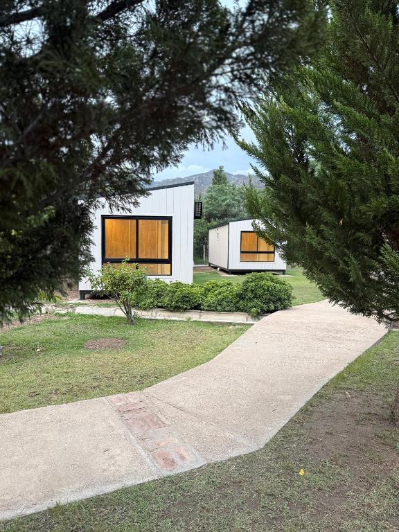 a white house with two windows on a yard at Casa María - Sanagasta in Villa Bustos
