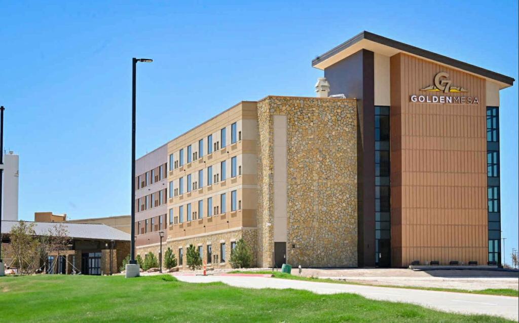 a building with a sign on the side of it at Golden Mesa Hotel in Guymon