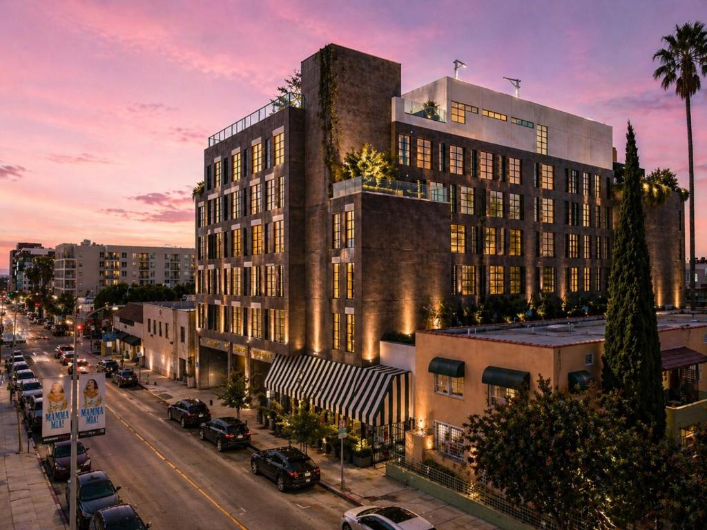 a tall building on a city street with cars parked at Whisky Hotel in Los Angeles
