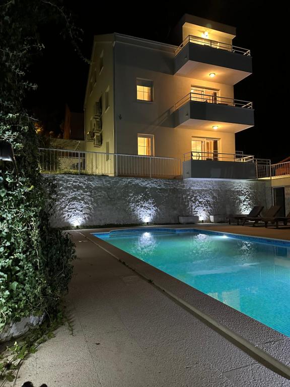 a house with a swimming pool in front of a building at My place Čiovo holiday house in Žedno