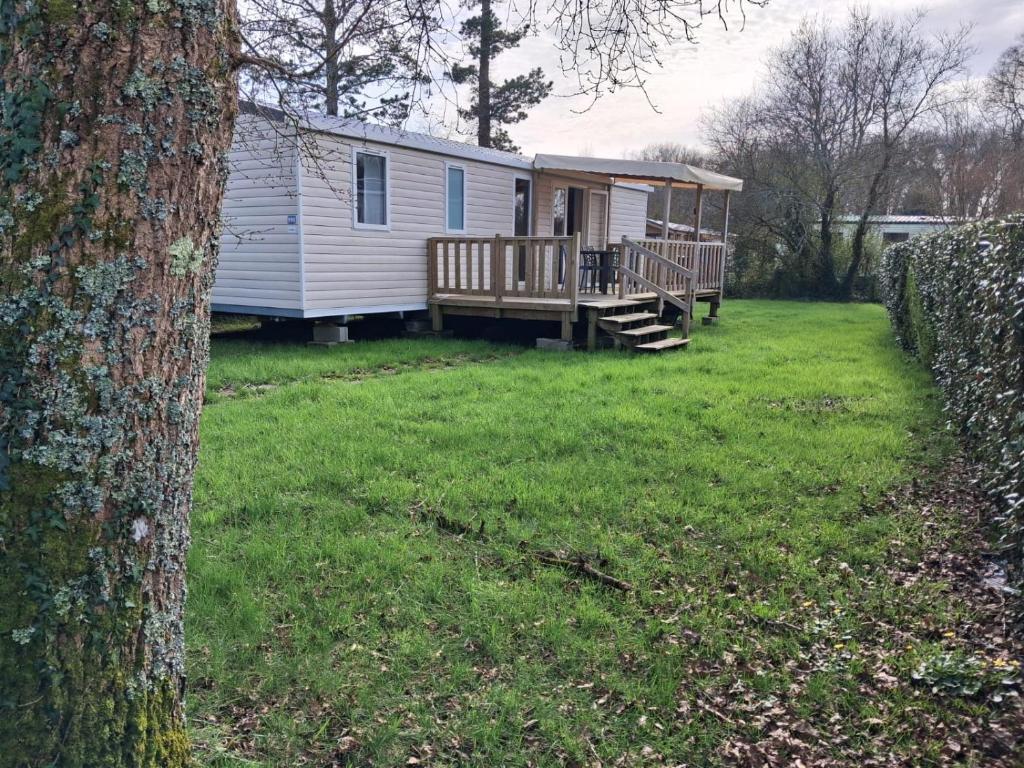a mobile home with a porch and a deck at Mobil home 590 in Pont-Aven