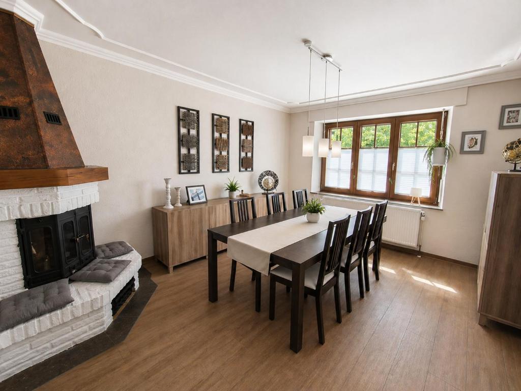 a dining room with a table and a fireplace at Sweet&City HOUSE in Saint-Vith