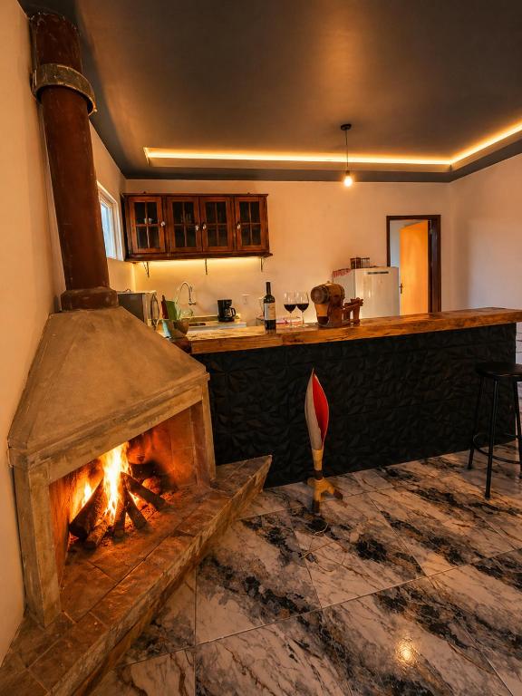 a kitchen with a fireplace in the middle of a room at Morada Iluminada Aconchego com Ar condicionado e Lareira in Miguel Pereira