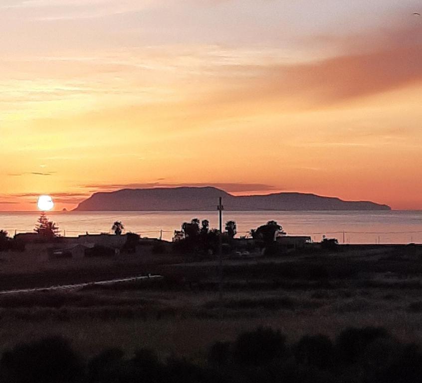 a sunset over the ocean with the sun in the sky at The house of the islands Sea view in Marausa