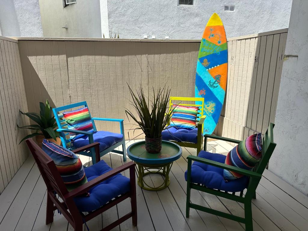 a group of chairs and a table and a surfboard at Surfer's Bungalow in San Diego