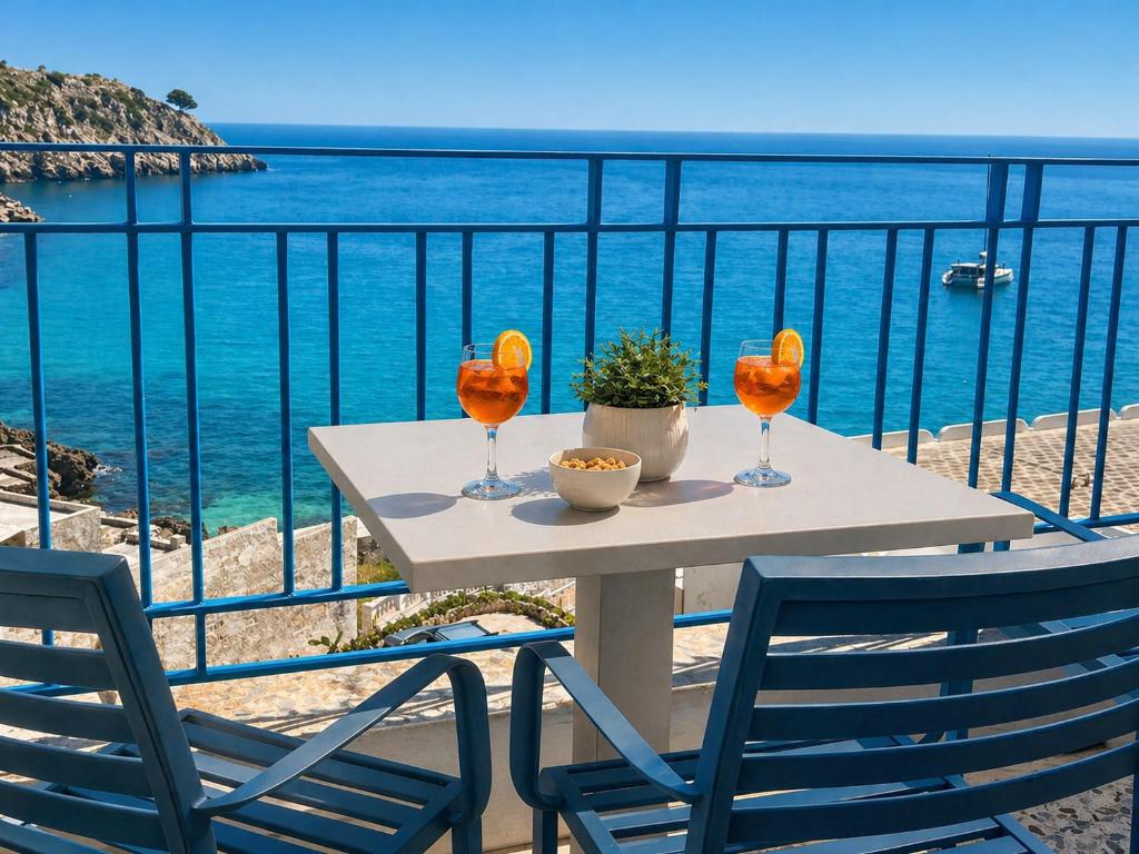a table with two chairs and a view of the ocean at Maré Rooms Castro in Castro di Lecce