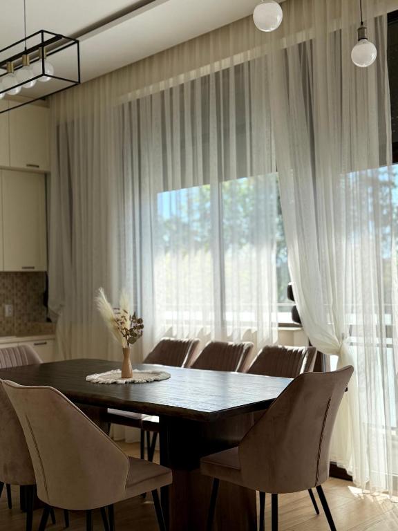 a dining room table with chairs and a large window at Easy Stay in Karlovo