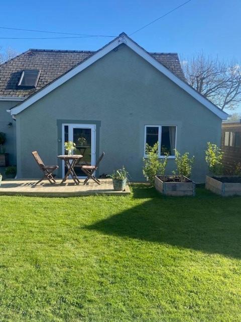a house with a table and chairs in a yard at The Garden Rooms in Spittal