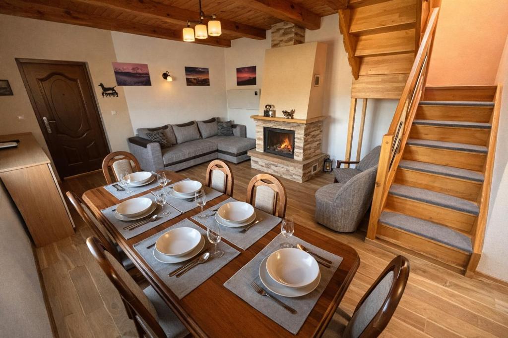 a living room with a table and a fireplace at Slnečný dvor Bukovinka in Dravce