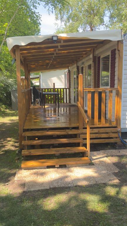 a cabin with a deck with a dog on it at Mobil home 148 in Pont-Aven
