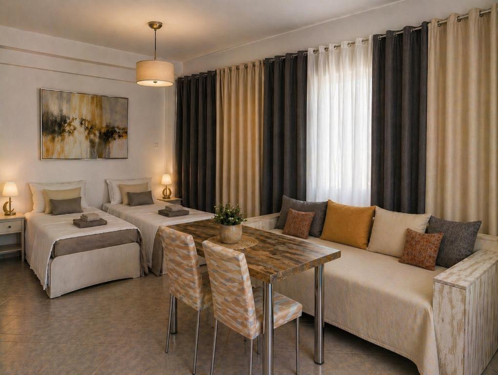 a hotel room with a couch and a bed and a table at Memories Studio in Neapoli Voion