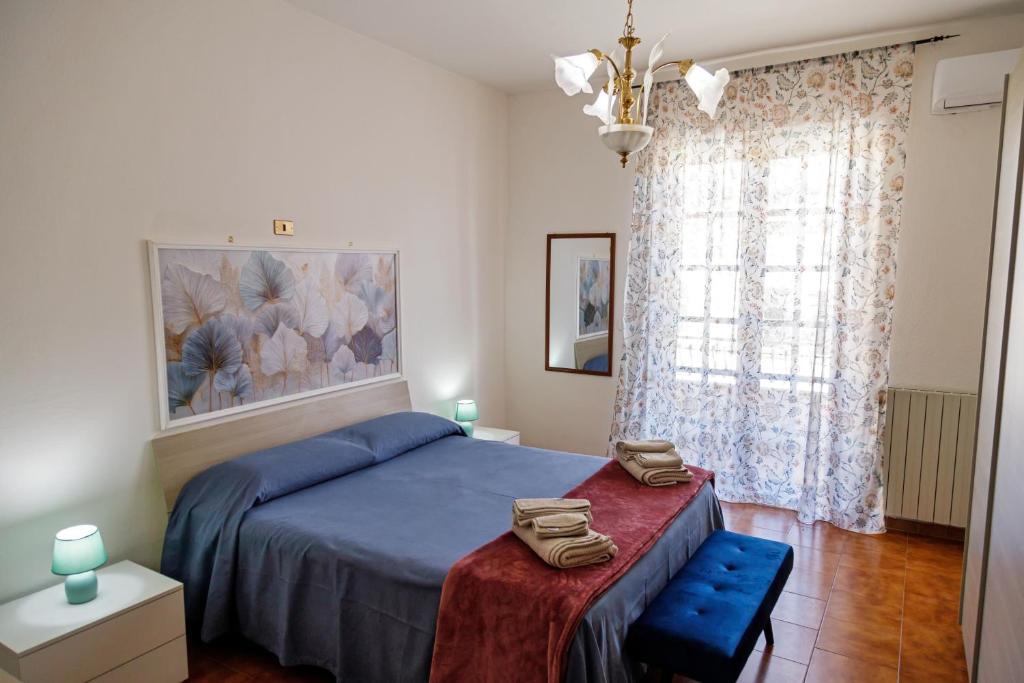 a bedroom with a blue bed and a window at Gli agrumi di Nonna Peppina - Appartamento Limoni in Mondragone