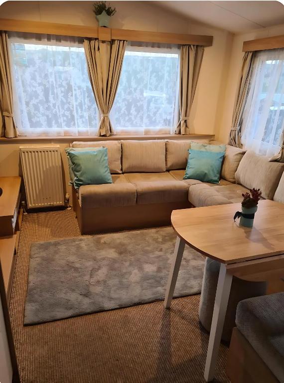 a living room with a couch and a table at Manderley Caravan in Newquay Bay Resort