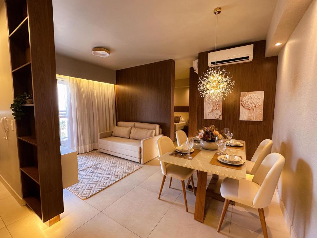 a dining room and living room with a table and chairs at Loft Prime Ribeirão Apogeo in Ribeirão Preto