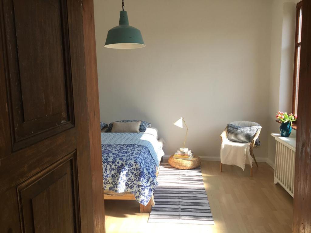 a bedroom with a bed and a lamp and a chair at Sommerhof im Havelland in Nennhausen