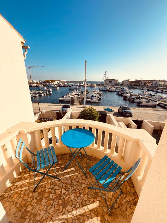 a balcony with two chairs and a table and a marina at SUPERBE maison, rénovée port de Carro -terrasse,calme & lumière in Martigues