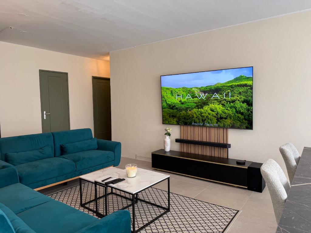 a living room with a blue couch and a flat screen tv at Le Cocon du Bord de Loire ! Appartement spacieux pour 6 personnes avec terrasse & parking in Nantes