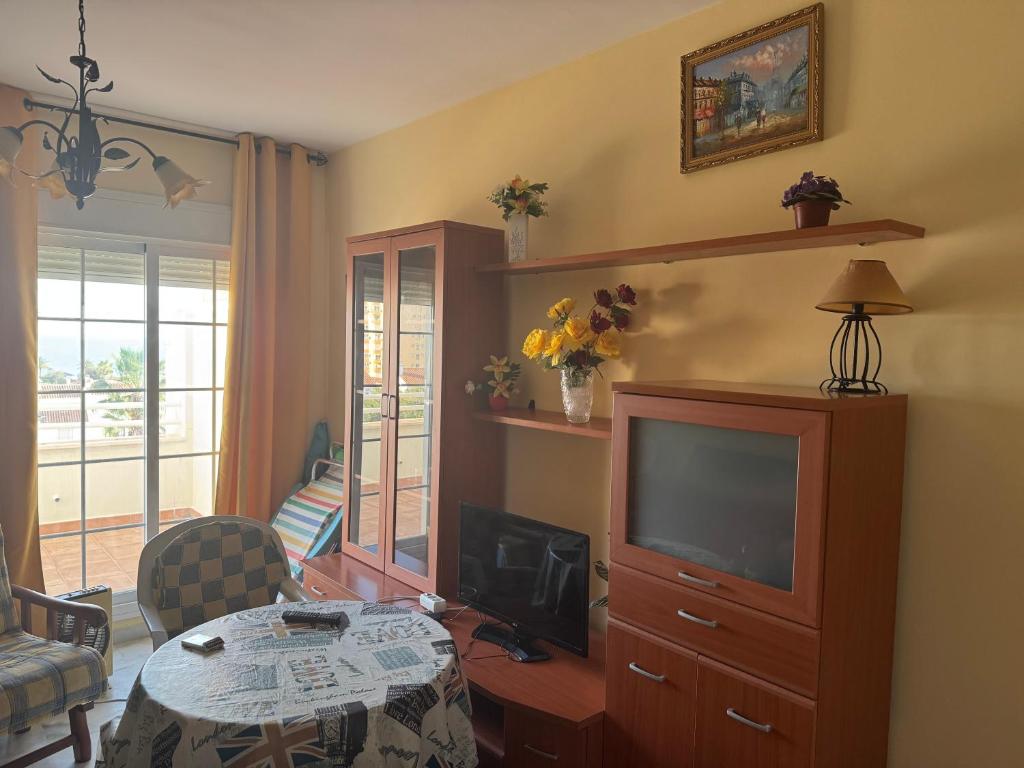 a living room with a television and a dining room table at Apartamento Torrox5 in Torrox Costa