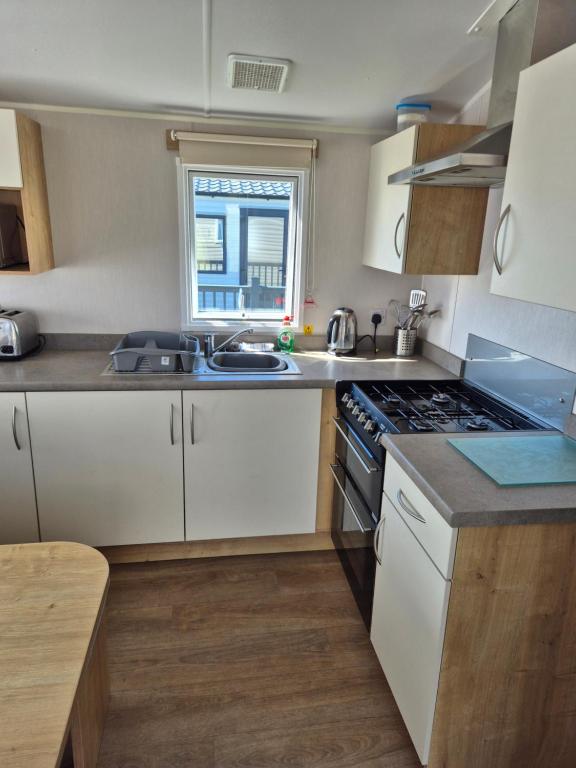 a kitchen with white cabinets and a stove top oven at Atlantic 63 in Bude