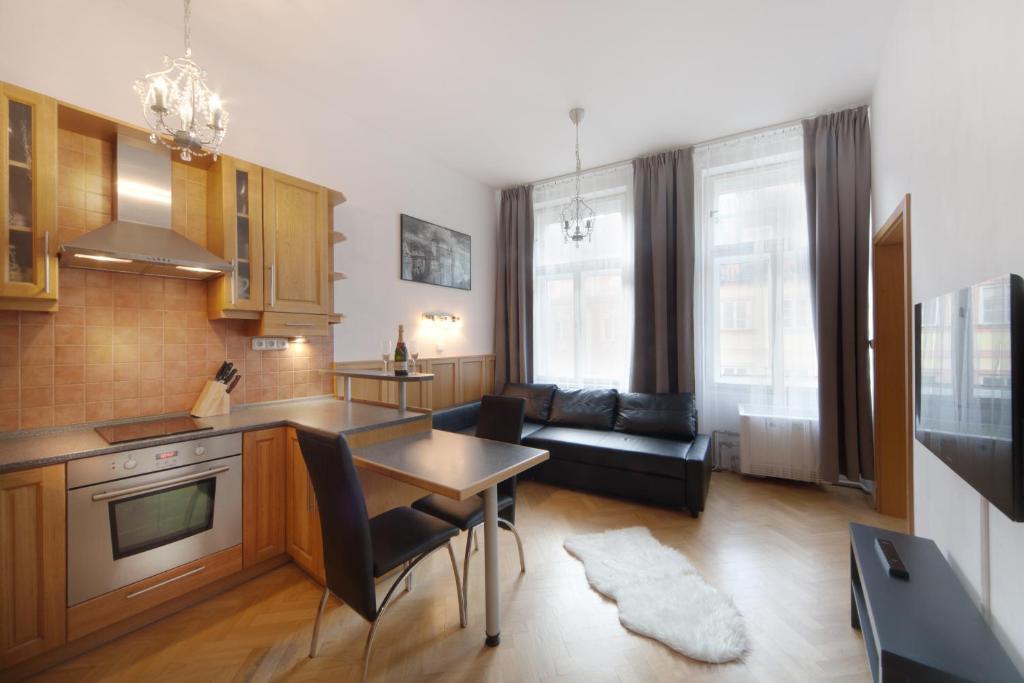 Il comprend une cuisine et un salon avec une table et un canapé. dans l'établissement Old Town Melantrichova Apartment, à Prague