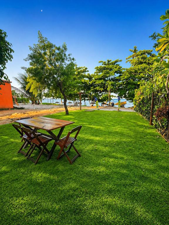 a picnic table and two benches in a park at Casa Medrado in Porto Seguro
