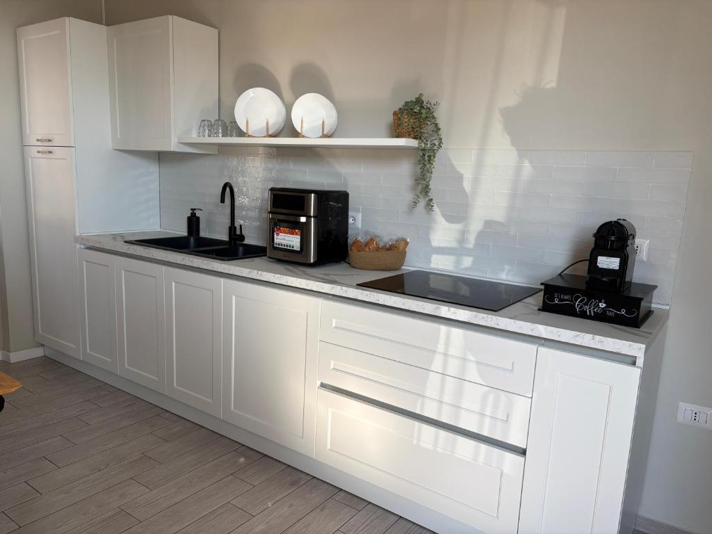 a kitchen with white cabinets and a counter with a microwave at Respiro Di Mare in Torre del Greco