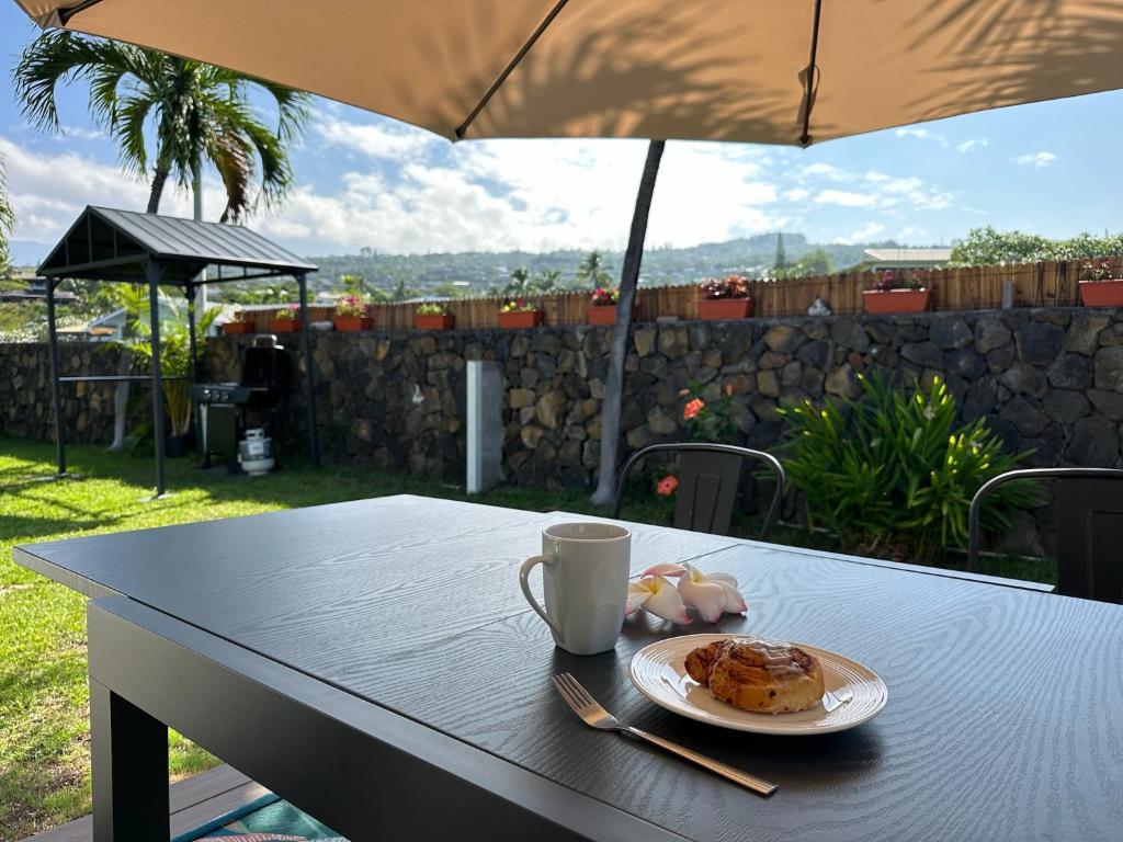 a table with a cup of coffee and pastries on it at Happy Hill Inn in Kailua-Kona