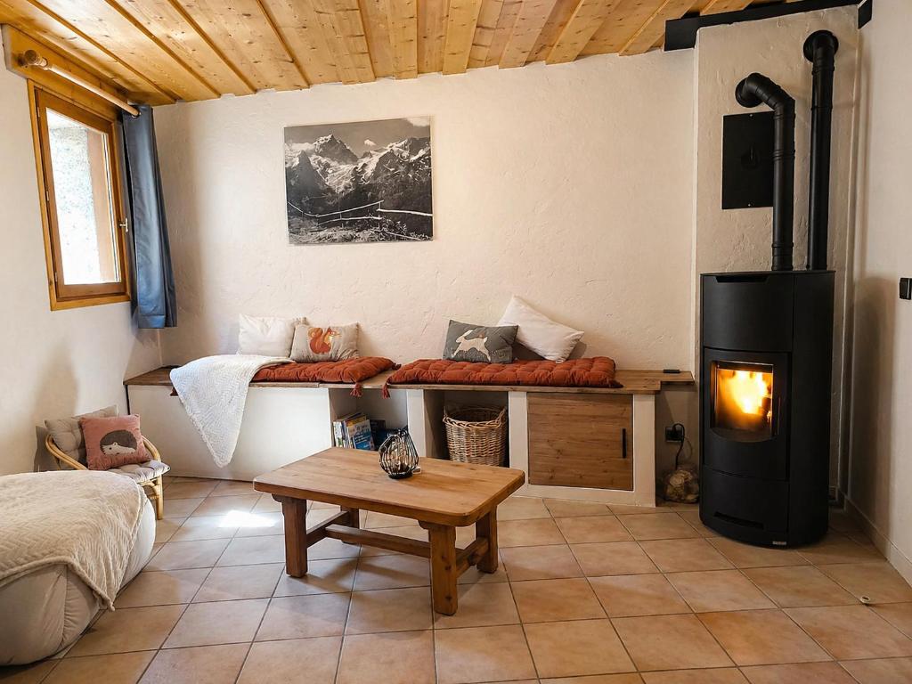 a living room with a wood stove and a table at Villa Silote in La Grave