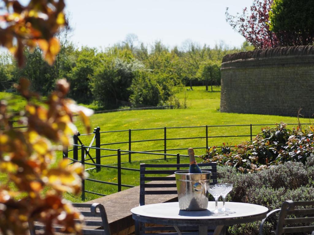 a table with a bottle of wine and a glass at Hobbs Hole Cottage & Studio in Great Tew