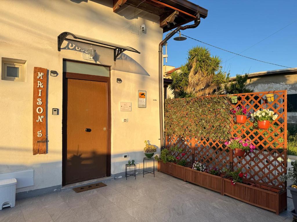 ein Gebäude mit einer braunen Tür und einem Zaun in der Unterkunft Maison 5 in Pellaro