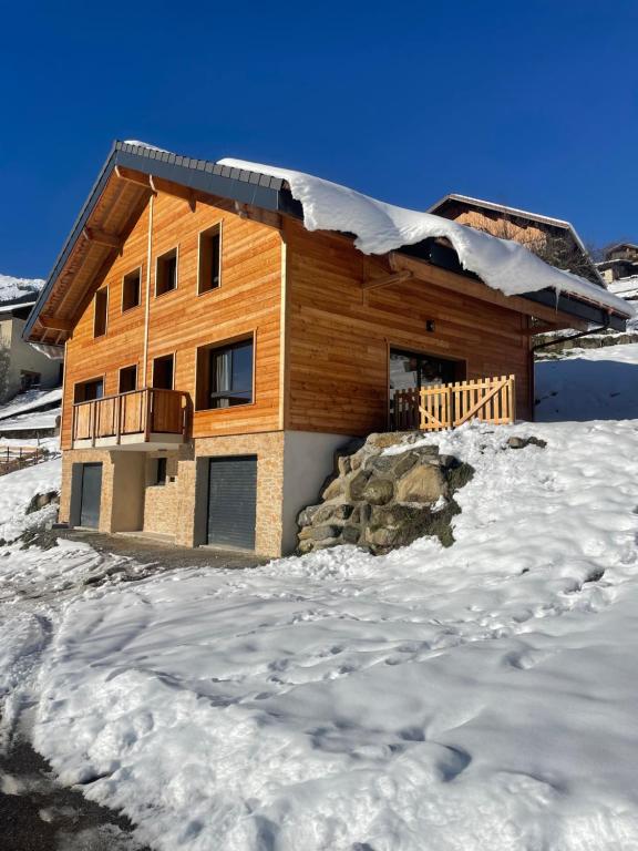 a log house in the snow with snow at Chalet cosy avec vue montagne proche La Clusaz & Le Grand-Bornand in Saint-Jean-de-Sixt