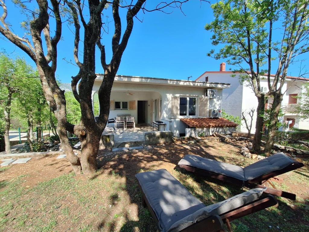 a house with a tree in front of it at Apartment Sia in Jadranovo