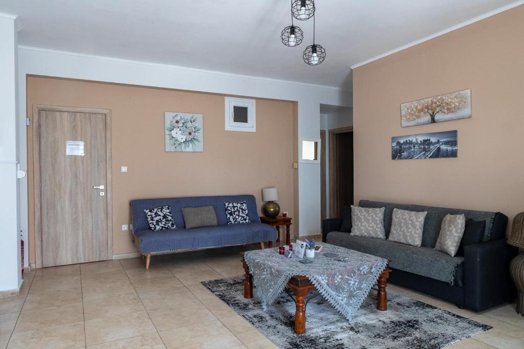 a living room with two blue couches and a table at Lanari Valley House in Thermi