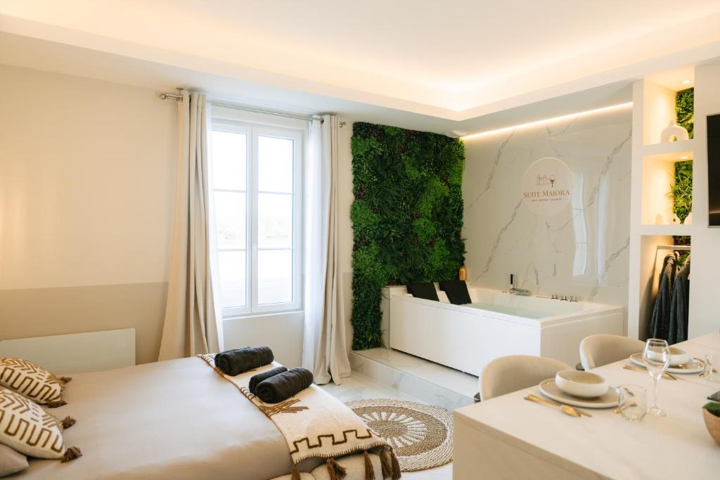 a bedroom with a bed and a tub in a room at Suite Maiora - Élégance, Sérénité & Jacuzzi in Saumur