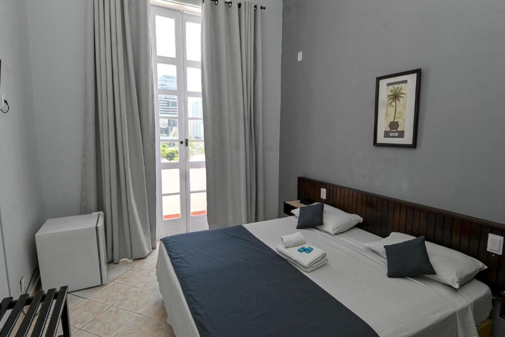 ein Schlafzimmer mit einem Bett und einem Fenster in der Unterkunft Hotel Carioca in Rio de Janeiro