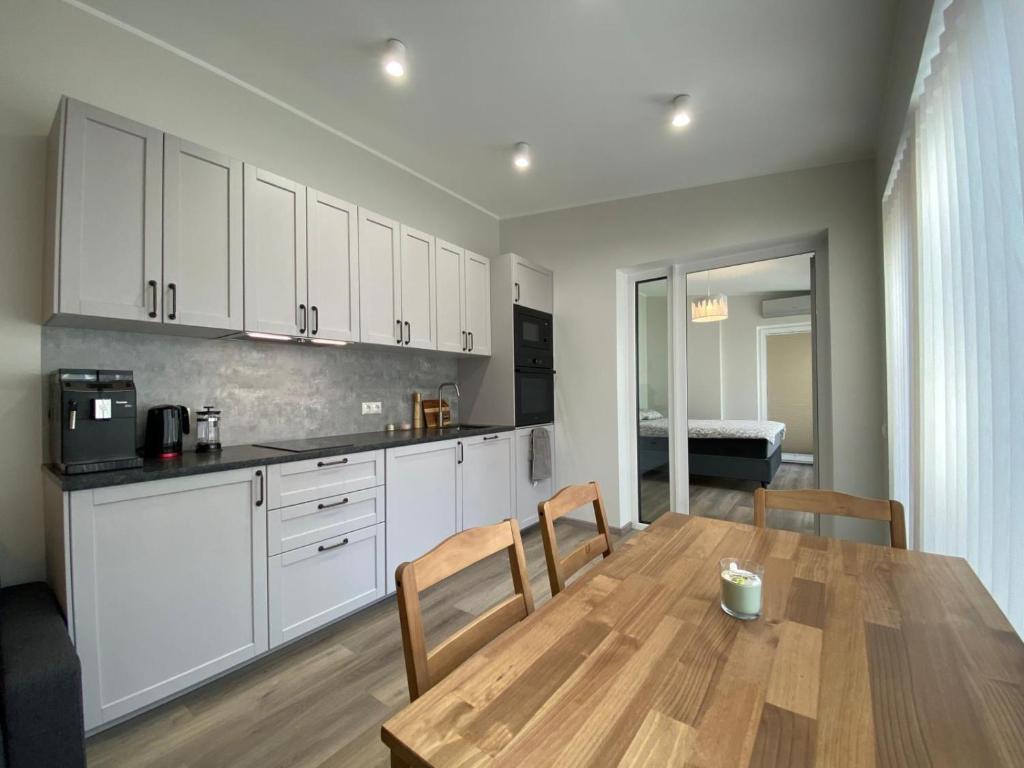 a kitchen with a wooden table and white cabinets at Hoovimaja in Pärnu