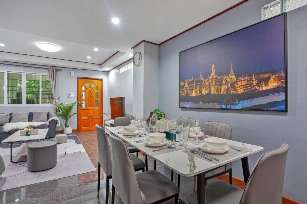 a dining room with a white table and chairs at Large Spacious 3BR House at BTS ON NUT in Phra Khanong