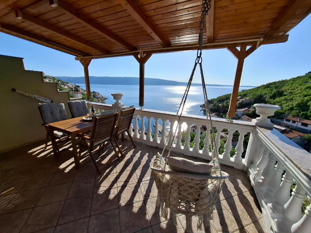 ein Balkon mit Tisch und Stühlen und Meerblick in der Unterkunft Apartment Biondić in Starigrad