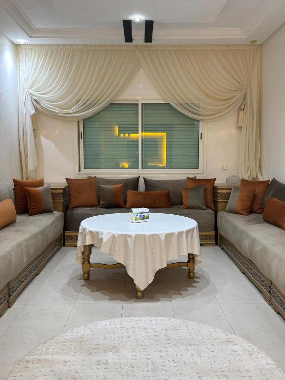a living room with a couch and a table at corniche d or piscine ferme le lundi in Mohammedia