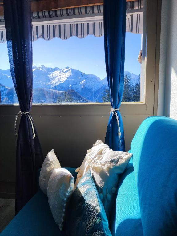 a bedroom with a window with a mountain view at Le Cocon Bleu in Ustou