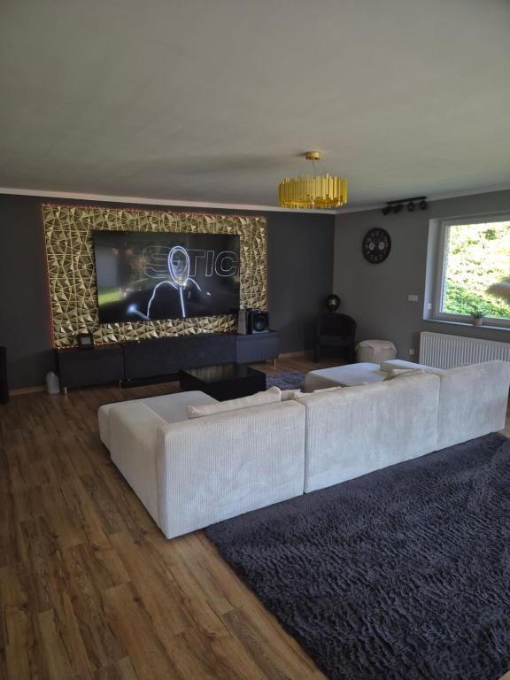 a living room with a white couch and a tv at Treuberg Rooms - Cuxhaven Northside in Cuxhaven