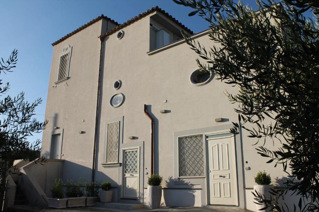 a white building with potted plants in front of it at Villa Carbonilla in Torre del Greco