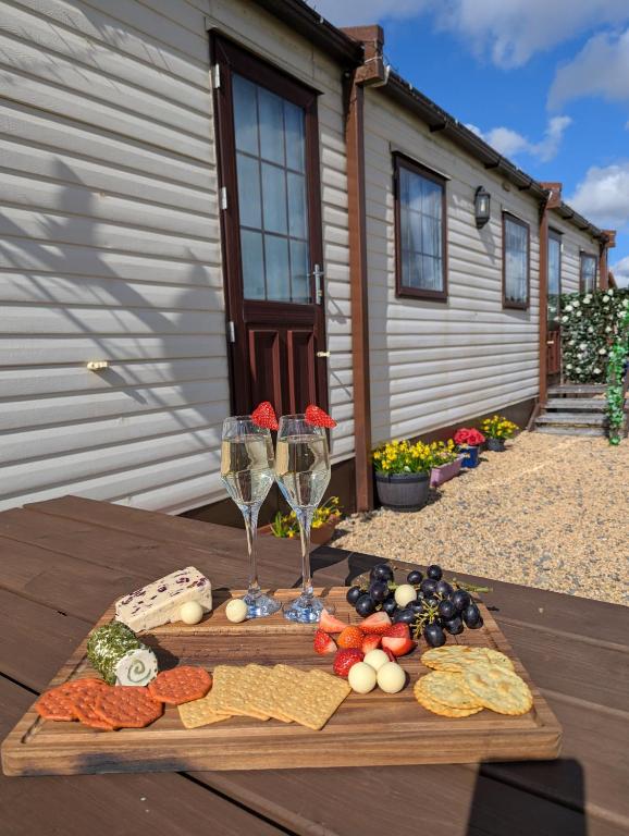 a wooden table with two glasses of wine and vegetables at Attymchugh Lodge in Corlee