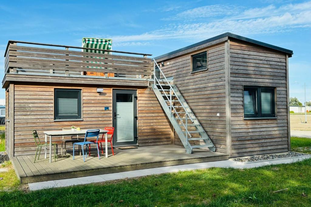 a small house with a staircase on the deck at Tiny House Boddenblick in Groß Kordshagen
