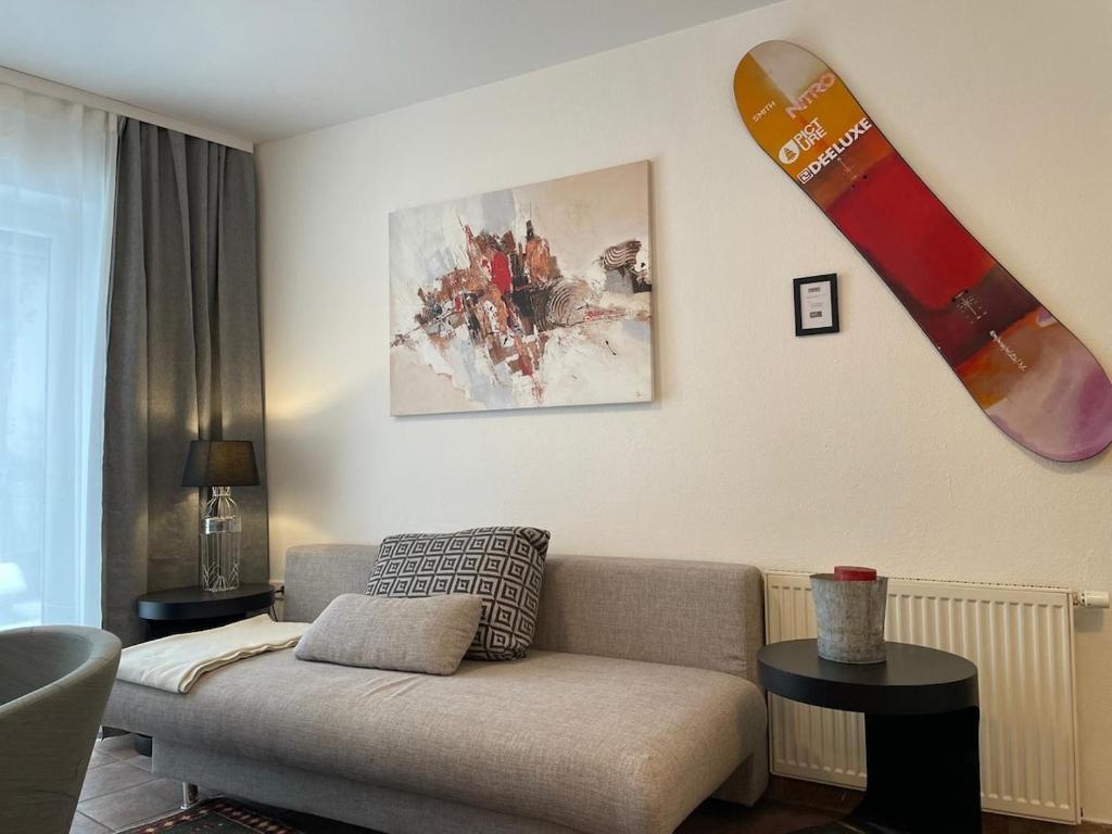 a living room with a couch and a snowboard on the wall at Innside - Terrace and Mountain Views in Innsbruck